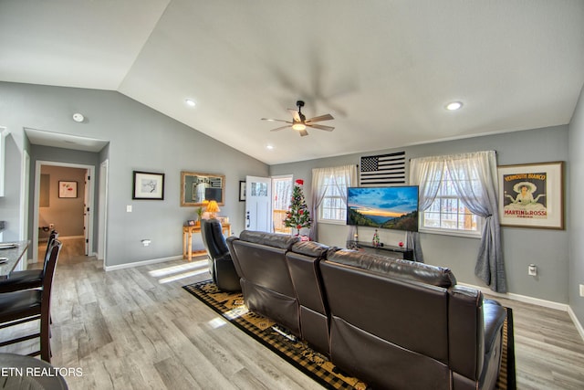 living room with ceiling fan, light hardwood / wood-style floors, and lofted ceiling