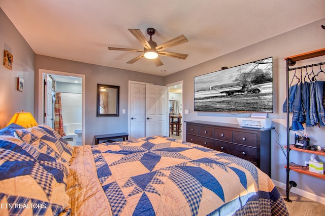 bedroom featuring hardwood / wood-style floors, ceiling fan, and connected bathroom