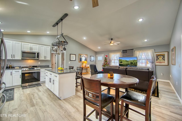 kitchen with ceiling fan, a center island, hanging light fixtures, appliances with stainless steel finishes, and light wood-type flooring