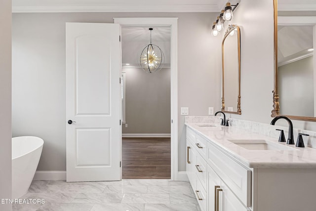 bathroom featuring an inviting chandelier, ornamental molding, a tub to relax in, vanity, and hardwood / wood-style flooring