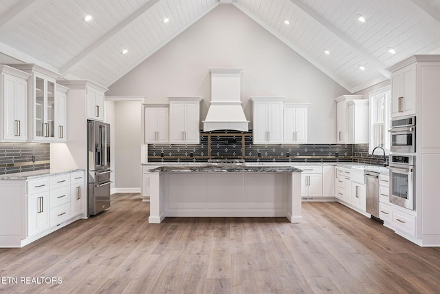 kitchen featuring a kitchen island, high vaulted ceiling, light hardwood / wood-style floors, white cabinets, and custom exhaust hood