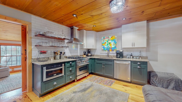 kitchen with stainless steel appliances, sink, wall chimney range hood, light hardwood / wood-style flooring, and white cabinetry