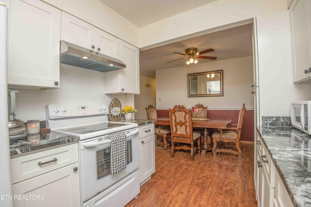 kitchen with ceiling fan, dark hardwood / wood-style flooring, backsplash, white appliances, and white cabinets