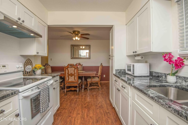 kitchen with white appliances, dark wood-type flooring, ceiling fan, dark stone countertops, and white cabinetry