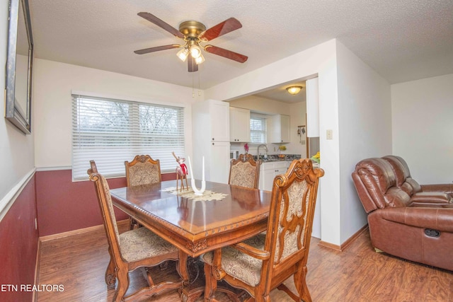 dining space featuring a textured ceiling, hardwood / wood-style flooring, and ceiling fan