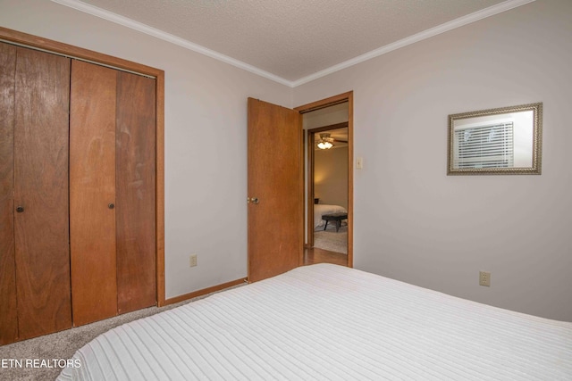 bedroom featuring crown molding, a closet, and a textured ceiling