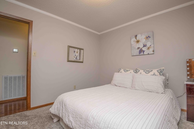 bedroom featuring carpet flooring, crown molding, and a textured ceiling