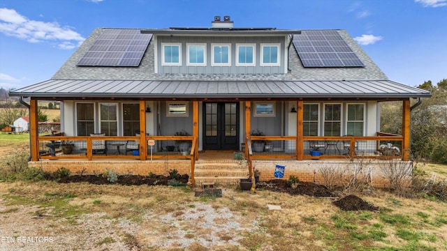 back of property featuring solar panels and a porch