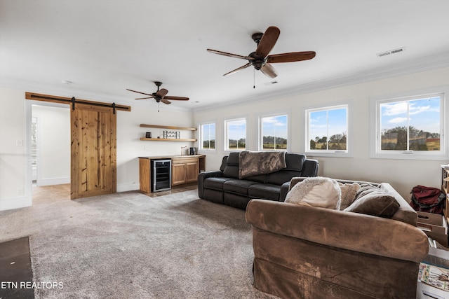 living room featuring beverage cooler, a barn door, light colored carpet, indoor bar, and ornamental molding