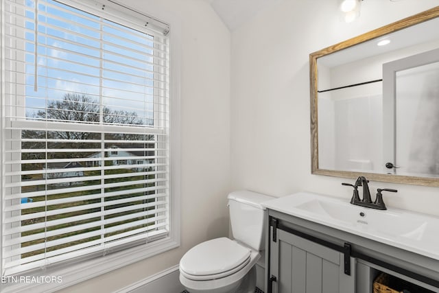 bathroom featuring walk in shower, vanity, a healthy amount of sunlight, and toilet