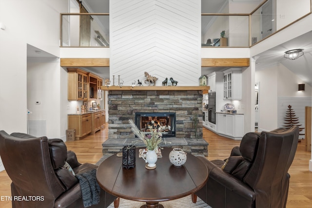 1430 Maple Ln, Greenback, TN 37742 - living room featuring a towering ceiling, light wood-type flooring, a fireplace, and crown molding