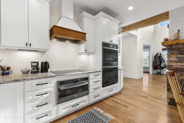 1430 Maple Ln, Greenback, TN 37742 - kitchen featuring custom exhaust hood, double wall oven, black electric cooktop, white cabinetry, and light wood-style floors