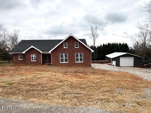 view of front of house featuring a garage and an outbuilding