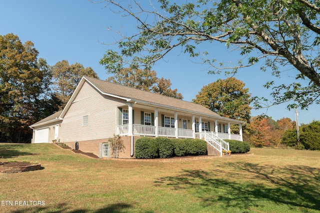 view of front of house with a front lawn, covered porch, and a garage