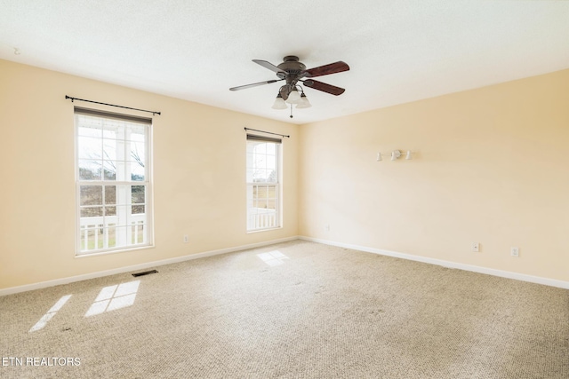 carpeted spare room with ceiling fan