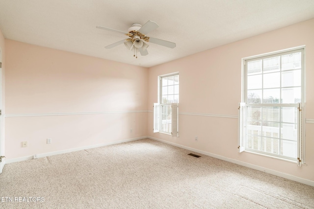 carpeted spare room featuring ceiling fan