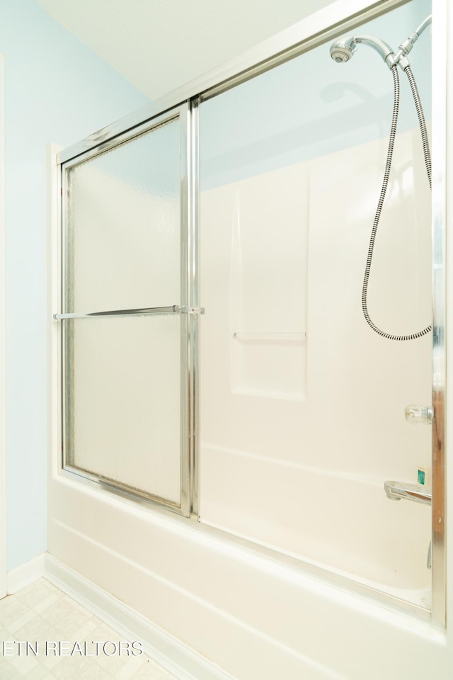 bathroom with combined bath / shower with glass door