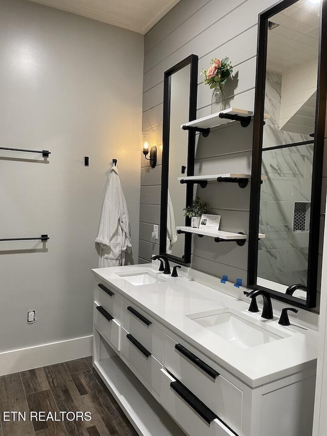 bathroom featuring hardwood / wood-style floors, vanity, walk in shower, and wood walls