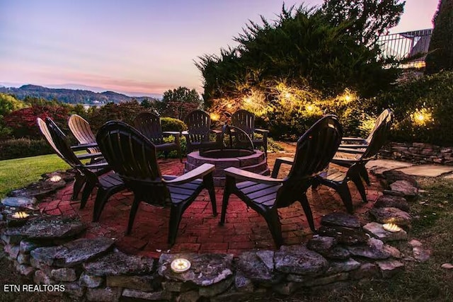 patio terrace at dusk with a fire pit and a mountain view