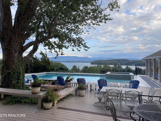 view of pool with a deck with water view