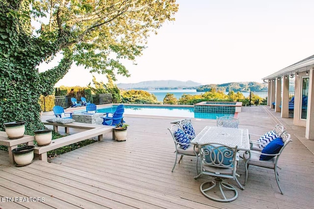 view of pool featuring a deck with water view