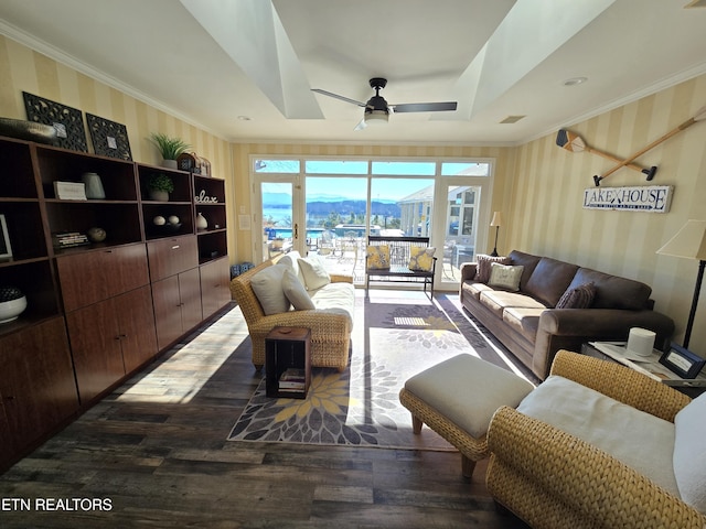 living room with a raised ceiling, ceiling fan, dark hardwood / wood-style flooring, and a mountain view