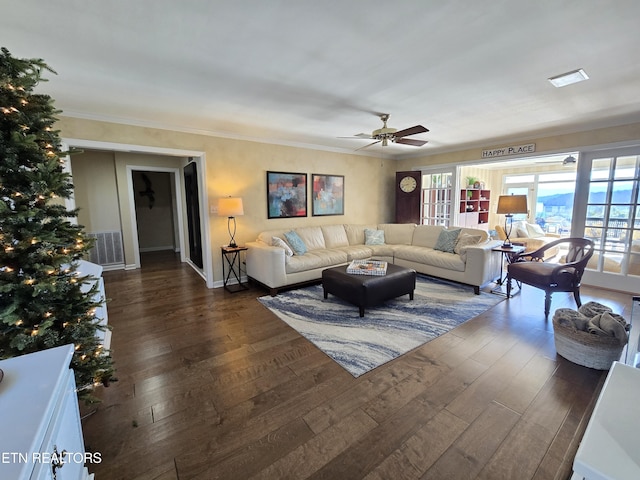 living room with ornamental molding, ceiling fan, and dark wood-type flooring