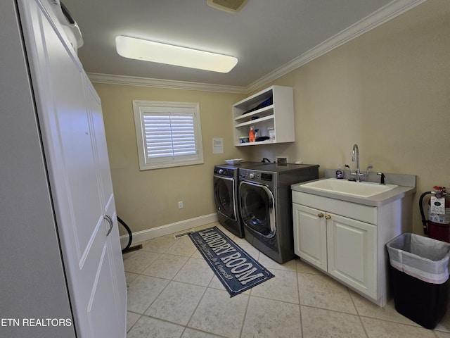 clothes washing area featuring cabinets, separate washer and dryer, sink, and ornamental molding