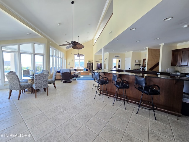 interior space with a breakfast bar, light tile patterned floors, and a wealth of natural light