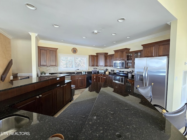 kitchen with backsplash, crown molding, sink, and appliances with stainless steel finishes