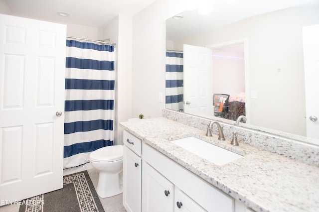 bathroom with tile patterned flooring, vanity, and toilet