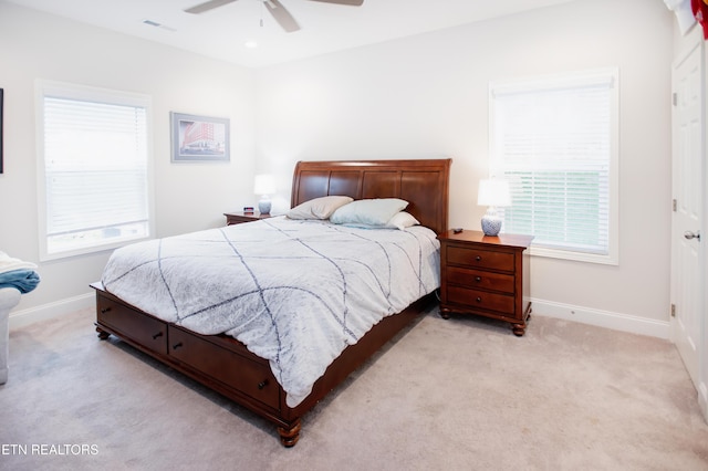 carpeted bedroom with multiple windows and ceiling fan