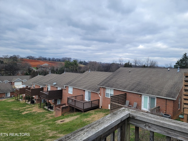 rear view of house with a lawn and a wooden deck