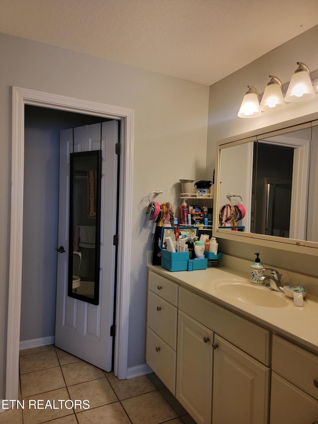 bathroom featuring tile patterned flooring, a textured ceiling, and vanity