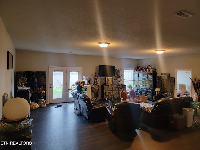 living room with a textured ceiling and dark wood-type flooring