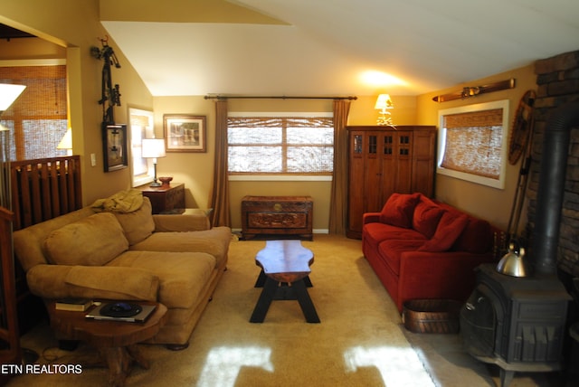 living room featuring a wood stove, light carpet, and vaulted ceiling