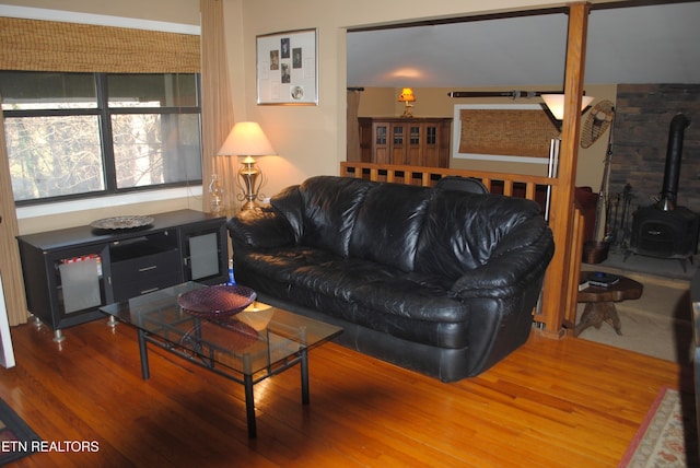 living room featuring wood-type flooring and a wood stove