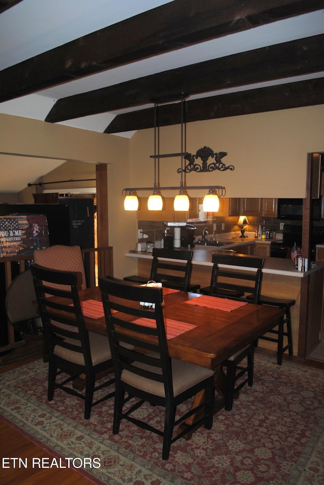 dining space with vaulted ceiling with beams and sink