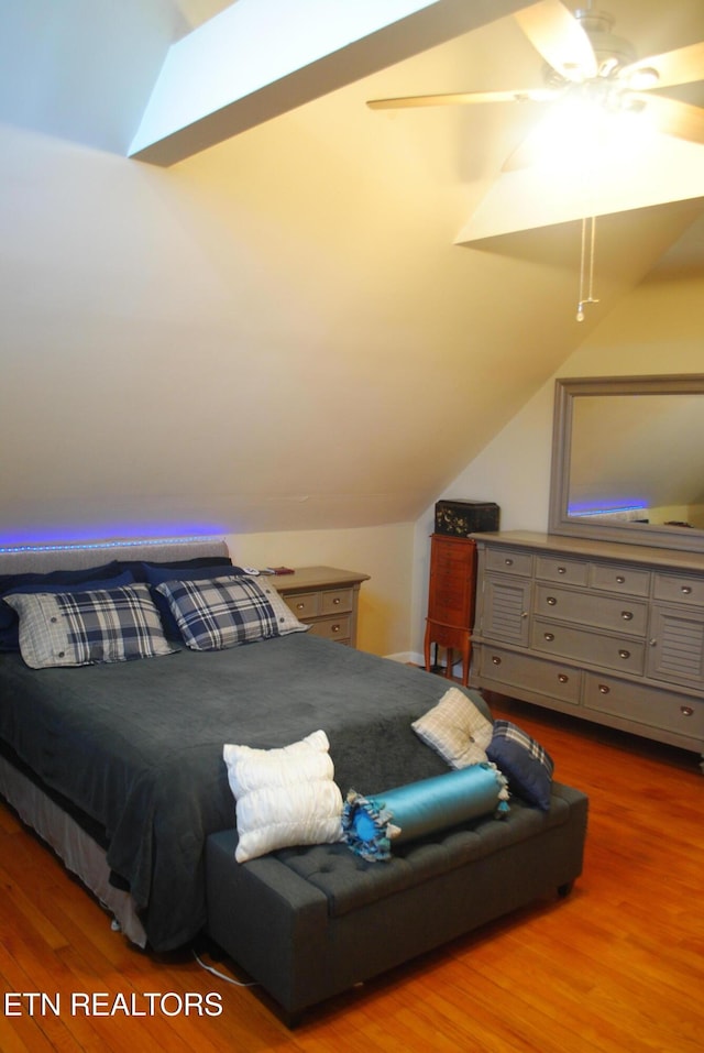 bedroom featuring ceiling fan, wood-type flooring, and vaulted ceiling