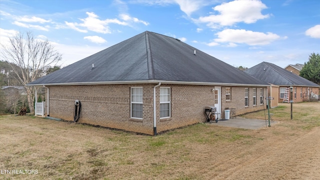 rear view of property featuring a patio and a lawn