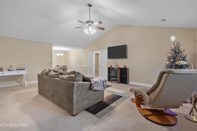 living room with ceiling fan with notable chandelier, light colored carpet, and lofted ceiling