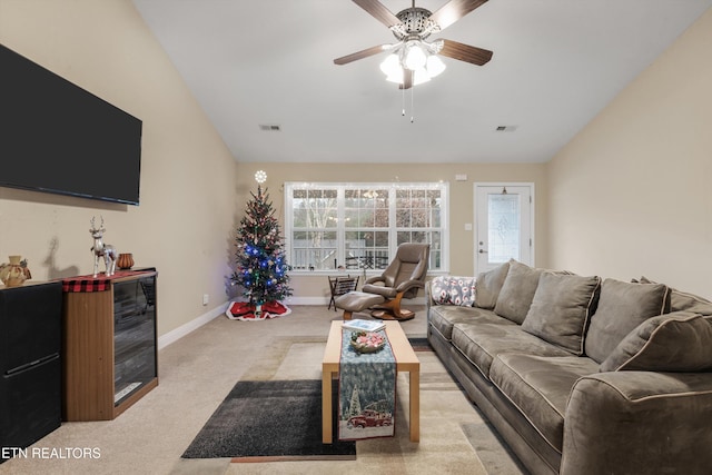 living room featuring ceiling fan, light colored carpet, and lofted ceiling