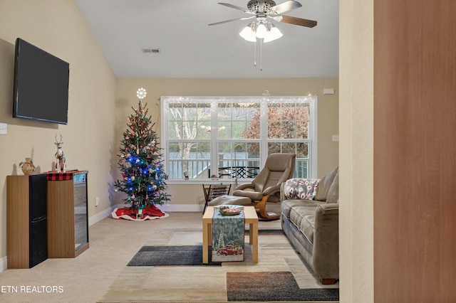 living room with ceiling fan, light carpet, and vaulted ceiling