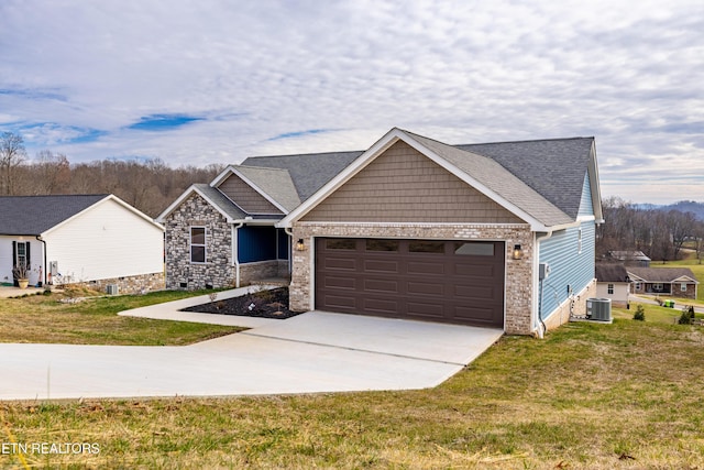 craftsman-style home with cooling unit, a garage, and a front yard