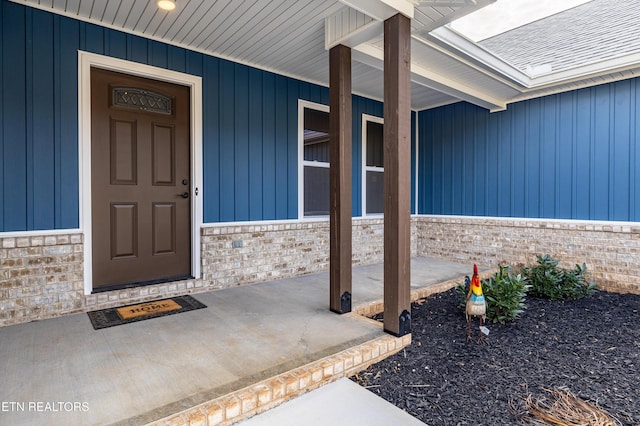 view of exterior entry featuring covered porch