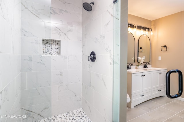 bathroom featuring tile patterned floors, vanity, a shower with shower door, and toilet