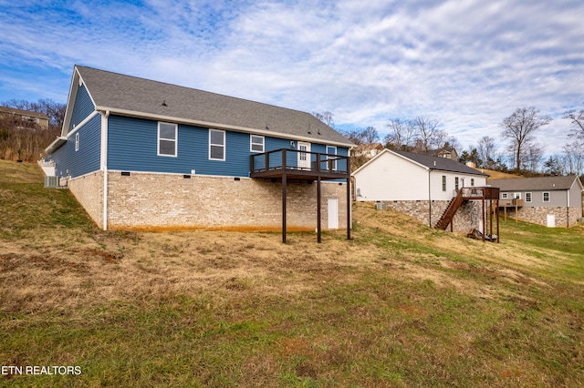 rear view of house featuring a lawn and a deck