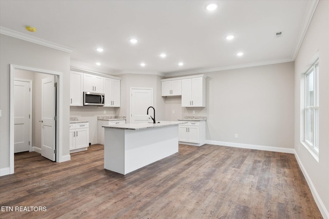 kitchen featuring dark hardwood / wood-style floors, an island with sink, light stone counters, and white cabinetry