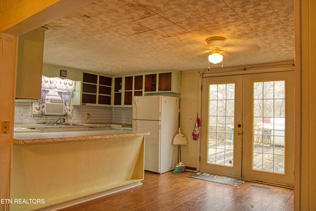 kitchen with decorative backsplash, french doors, hardwood / wood-style floors, and white refrigerator