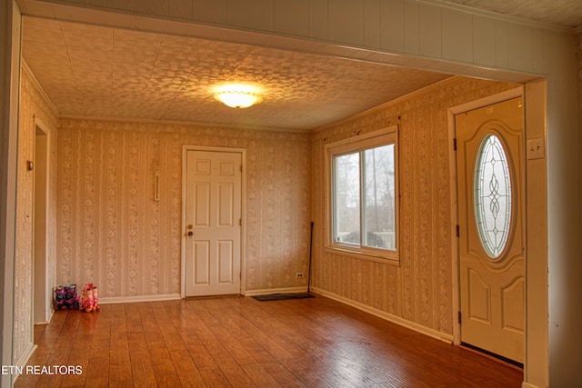 entrance foyer with hardwood / wood-style floors and ornamental molding